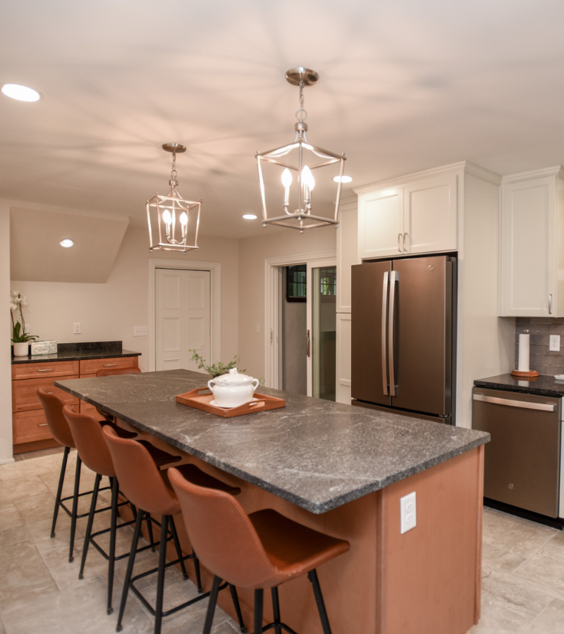 Modern kitchen with large island, leather seating, and stainless steel appliances by Build Dayton.